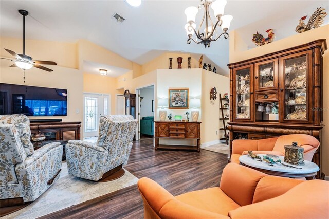 living room featuring lofted ceiling, ceiling fan with notable chandelier, and dark wood-type flooring