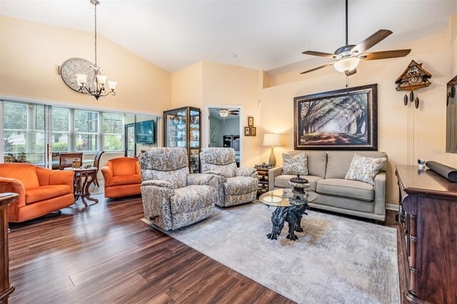 living room with ceiling fan with notable chandelier, high vaulted ceiling, and dark hardwood / wood-style floors