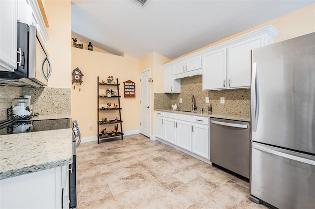 kitchen with stainless steel appliances, white cabinets, and tasteful backsplash