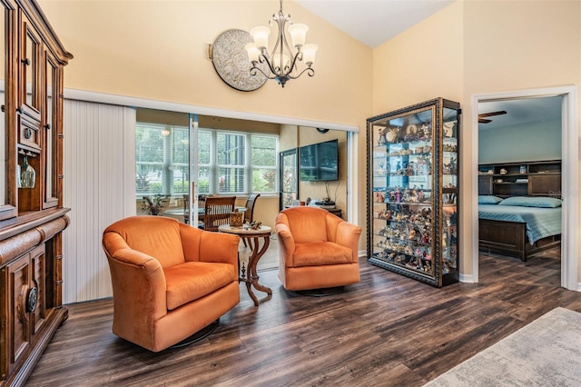 living area featuring dark hardwood / wood-style floors, a towering ceiling, and an inviting chandelier