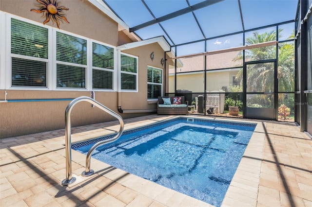 view of pool featuring glass enclosure and a patio area