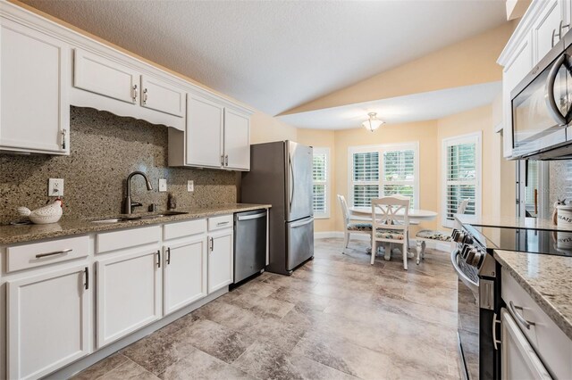 kitchen featuring stainless steel appliances, decorative backsplash, sink, light stone counters, and light tile patterned floors