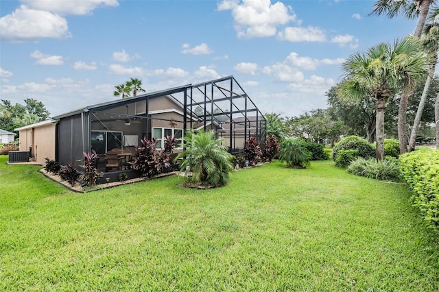 view of yard featuring glass enclosure and central AC