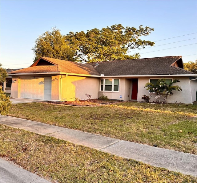 ranch-style home featuring a garage and a front yard