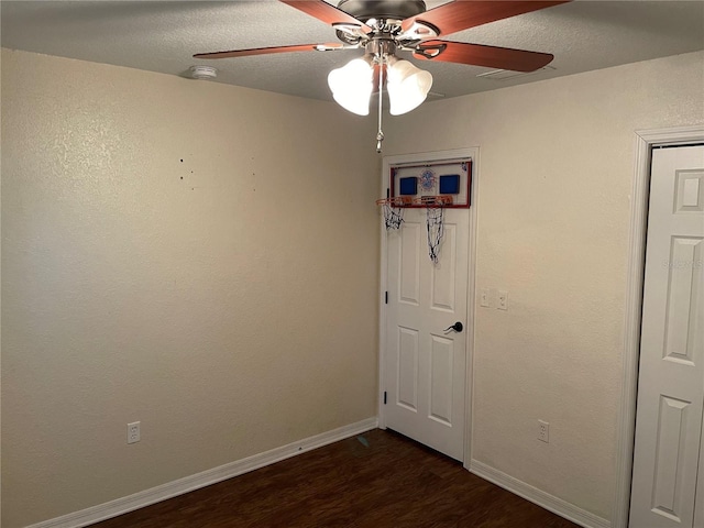 unfurnished room with ceiling fan, dark hardwood / wood-style flooring, and a textured ceiling