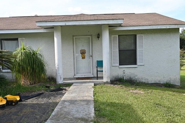 view of exterior entry with a yard