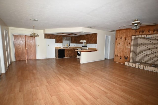 kitchen featuring ceiling fan with notable chandelier, decorative light fixtures, wood-type flooring, electric range, and kitchen peninsula