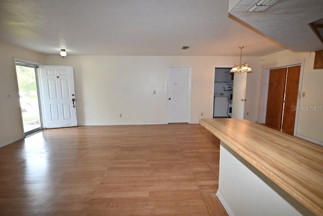 interior space featuring decorative light fixtures and light hardwood / wood-style floors