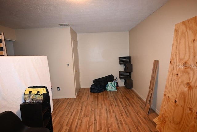 interior space featuring a textured ceiling and light wood-type flooring