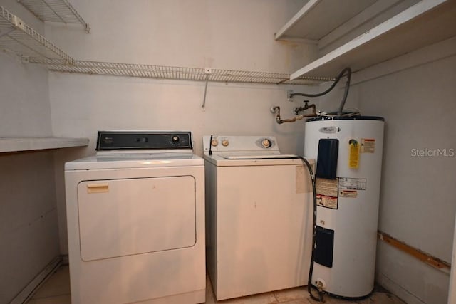 laundry room with light tile patterned flooring, electric water heater, and washer and dryer