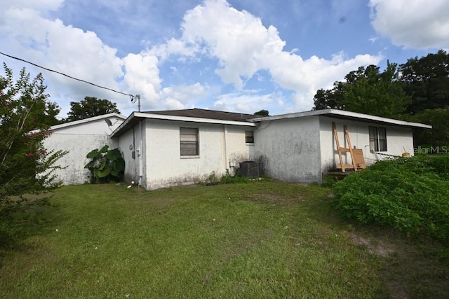 view of home's exterior with central AC unit and a lawn