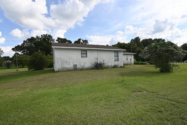 view of property exterior with a yard and central air condition unit