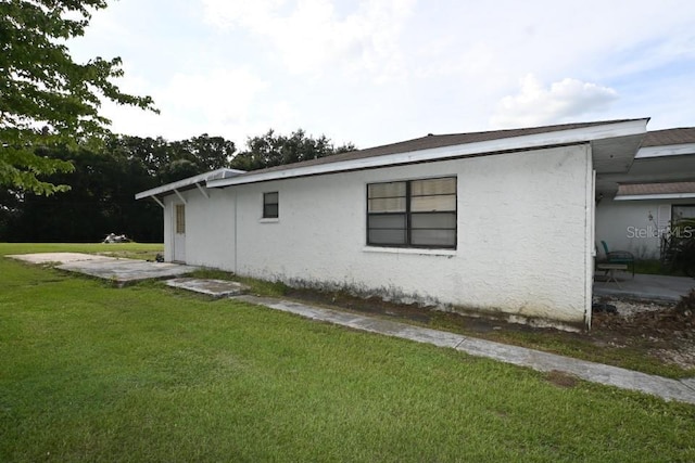 view of side of property with a yard and a patio