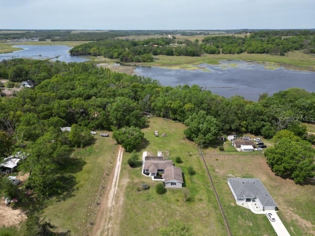 birds eye view of property featuring a wooded view and a water view