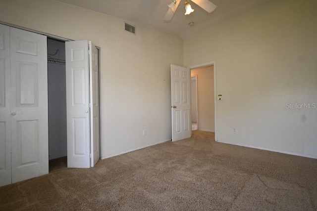 unfurnished bedroom with a closet, carpet flooring, ceiling fan, and visible vents