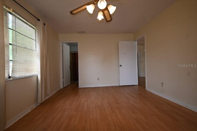 spare room with visible vents, wood finished floors, baseboards, and ceiling fan