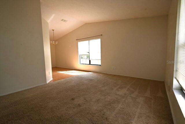 bonus room with lofted ceiling, a notable chandelier, carpet, and visible vents