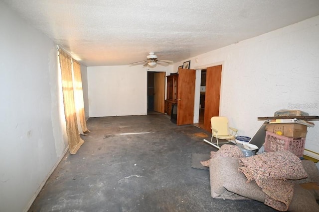 empty room with a textured ceiling, ceiling fan, and unfinished concrete floors