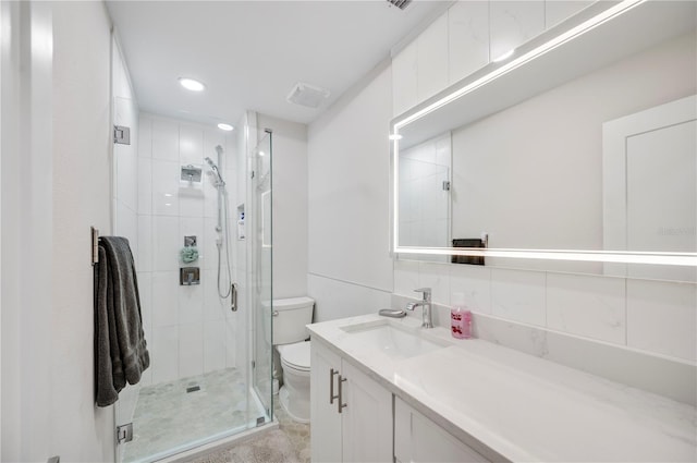 bathroom featuring backsplash, vanity, toilet, and walk in shower