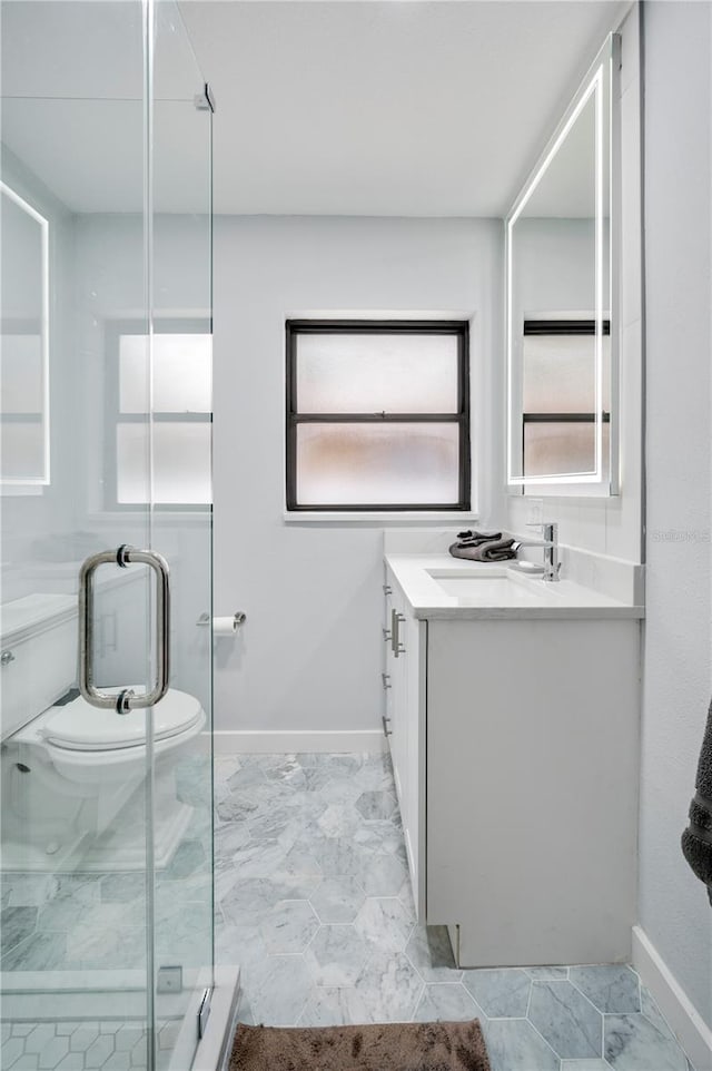 bathroom featuring a shower with door and vanity