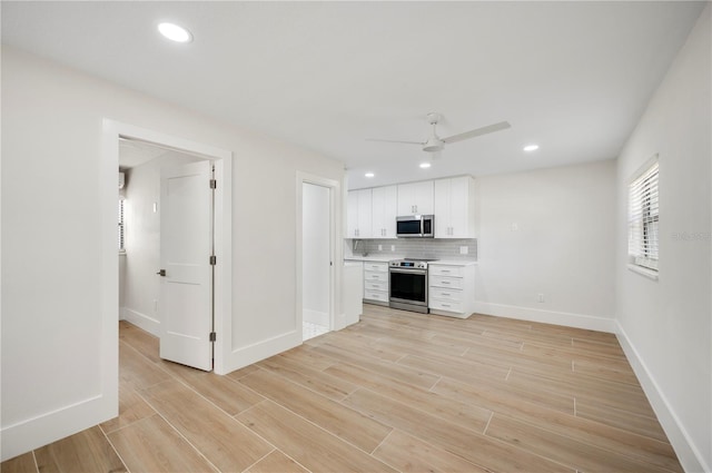 kitchen featuring white cabinets, backsplash, stainless steel appliances, and ceiling fan