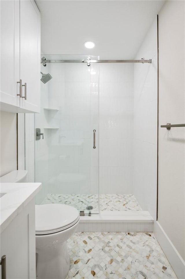 bathroom featuring tile patterned flooring, vanity, an enclosed shower, and toilet