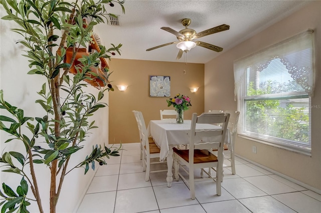 dining room featuring ceiling fan, light tile patterned floors, and a textured ceiling