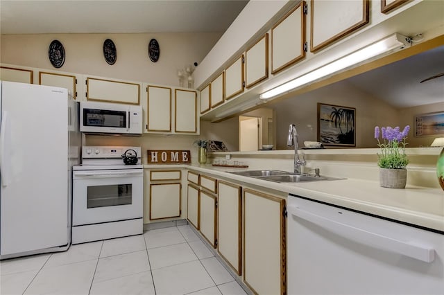 kitchen featuring sink, cream cabinets, lofted ceiling, white appliances, and light tile patterned floors