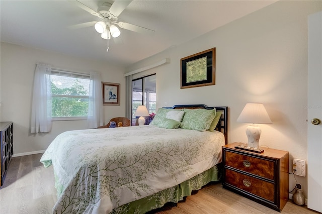 bedroom with light wood-type flooring, multiple windows, and ceiling fan