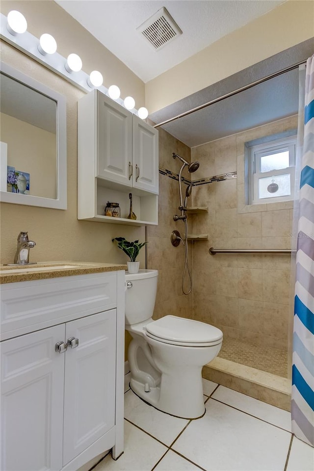 bathroom featuring tile patterned floors, a shower with curtain, toilet, and vanity