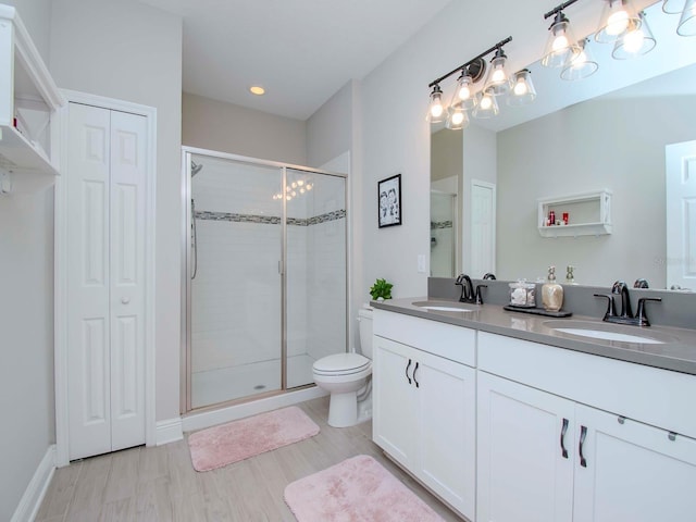 bathroom with vanity, toilet, an enclosed shower, and wood-type flooring