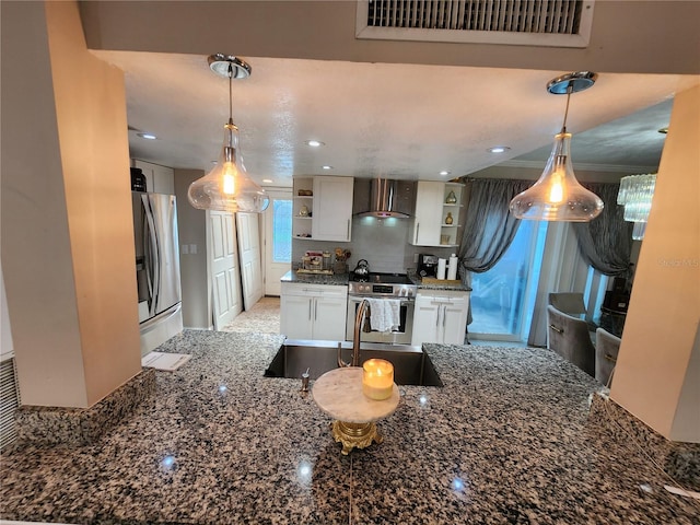 kitchen featuring appliances with stainless steel finishes, tasteful backsplash, white cabinets, dark stone countertops, and wall chimney exhaust hood