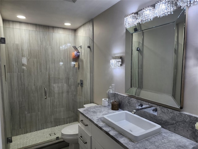 bathroom with walk in shower, toilet, and vanity