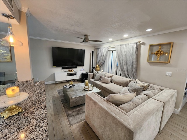 living room featuring a textured ceiling, ceiling fan, wood-type flooring, and ornamental molding