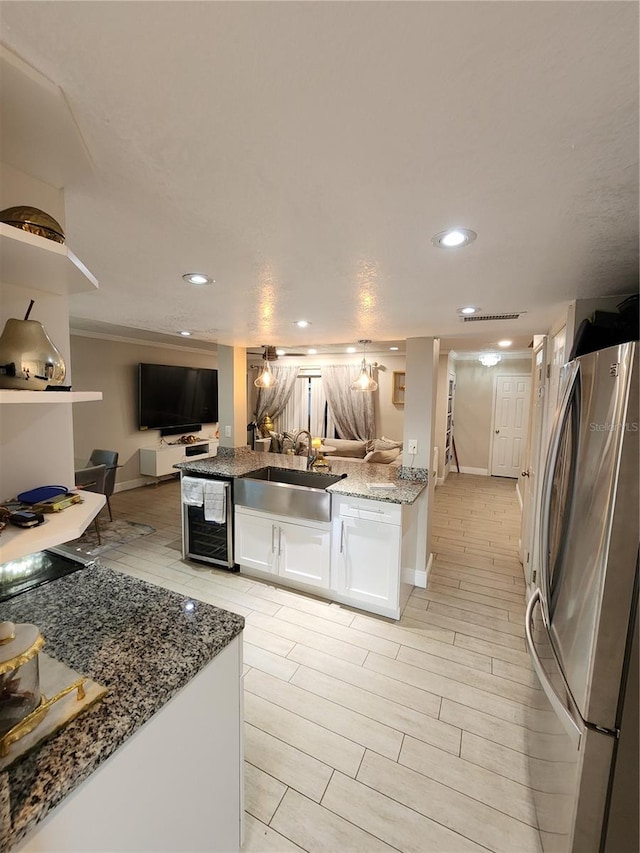 kitchen featuring white cabinetry, wine cooler, light hardwood / wood-style floors, stainless steel fridge, and sink