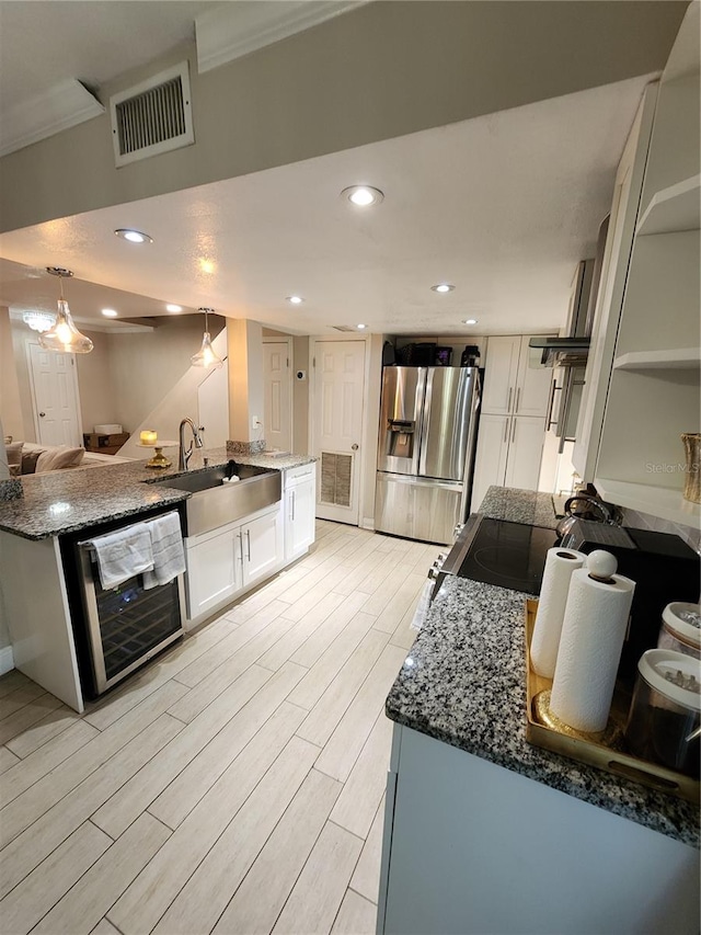 kitchen featuring stainless steel fridge with ice dispenser, dishwashing machine, light wood-type flooring, white cabinets, and sink