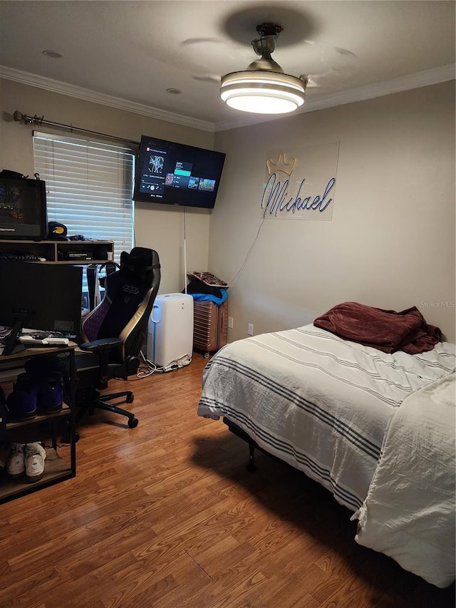 bedroom with hardwood / wood-style flooring and ornamental molding