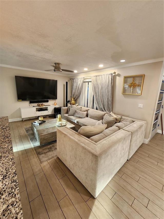 living room with ornamental molding, ceiling fan, and light wood-type flooring