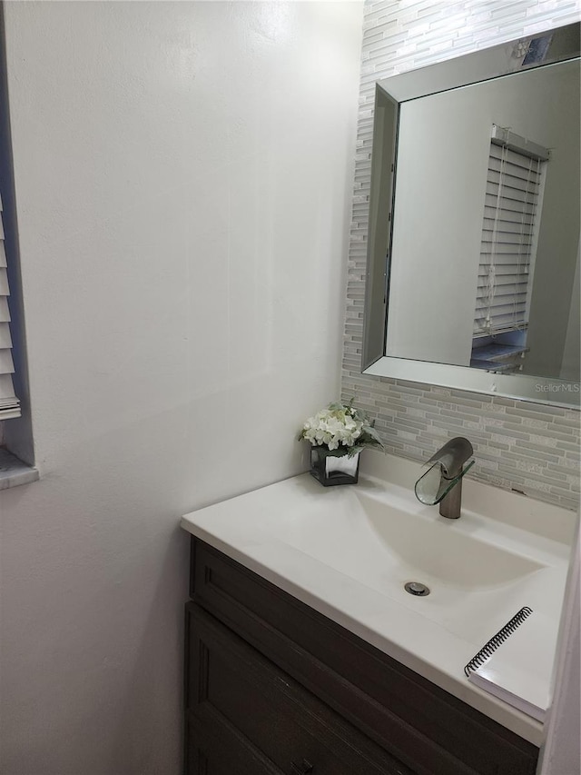 bathroom featuring vanity and decorative backsplash