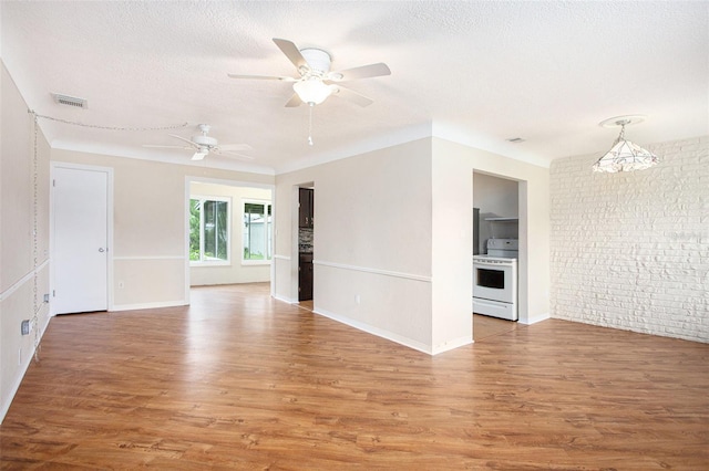 empty room with wood-type flooring, a textured ceiling, and ceiling fan