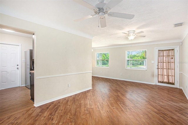 spare room with a textured ceiling, wood-type flooring, and ceiling fan