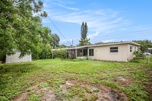 view of yard featuring a sunroom and a shed