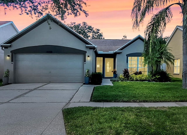 single story home featuring a yard and a garage