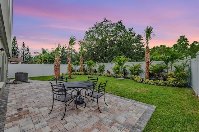 patio terrace at dusk featuring a yard