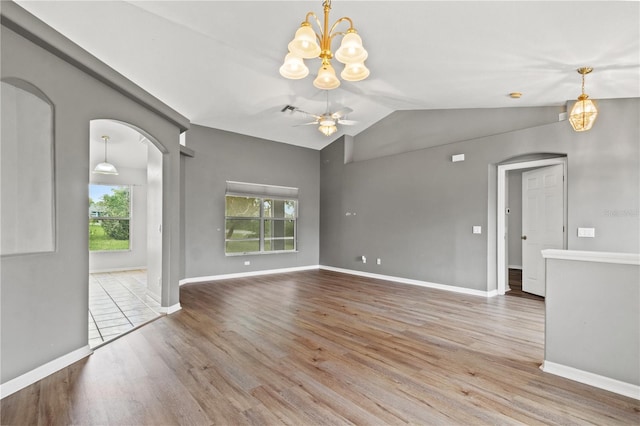 empty room featuring ceiling fan, hardwood / wood-style flooring, a wealth of natural light, and vaulted ceiling