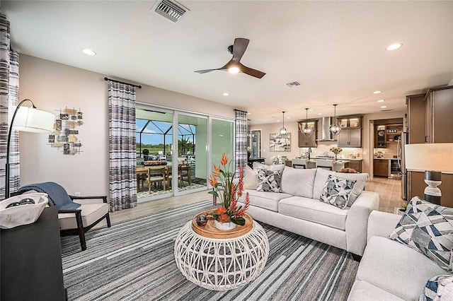 living room with ceiling fan and wood-type flooring