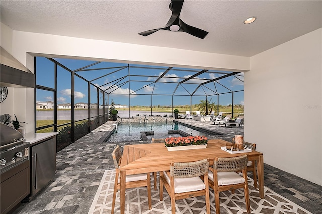 exterior space with a water view, pool water feature, ceiling fan, and glass enclosure