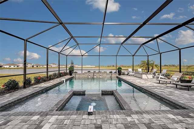 view of pool with an in ground hot tub, glass enclosure, and a patio area