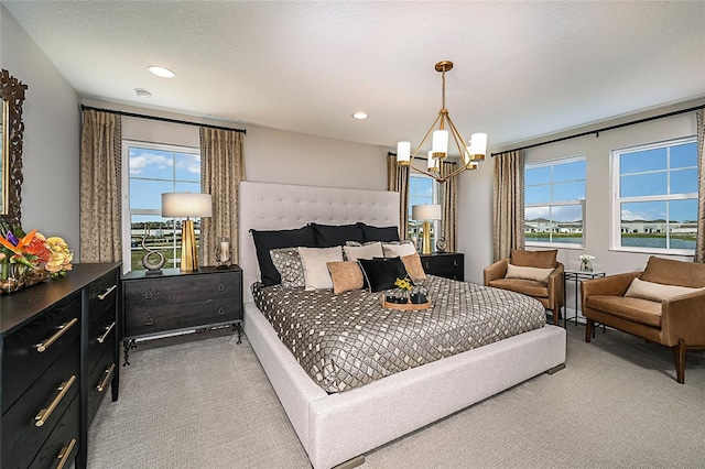 bedroom featuring multiple windows, light carpet, a chandelier, and a textured ceiling