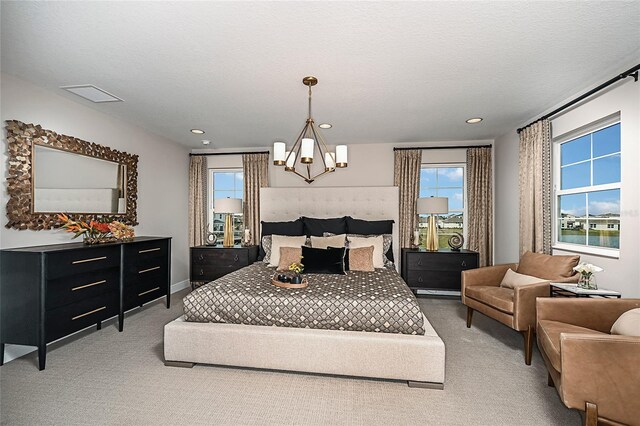 bedroom with an inviting chandelier, carpet, and a textured ceiling